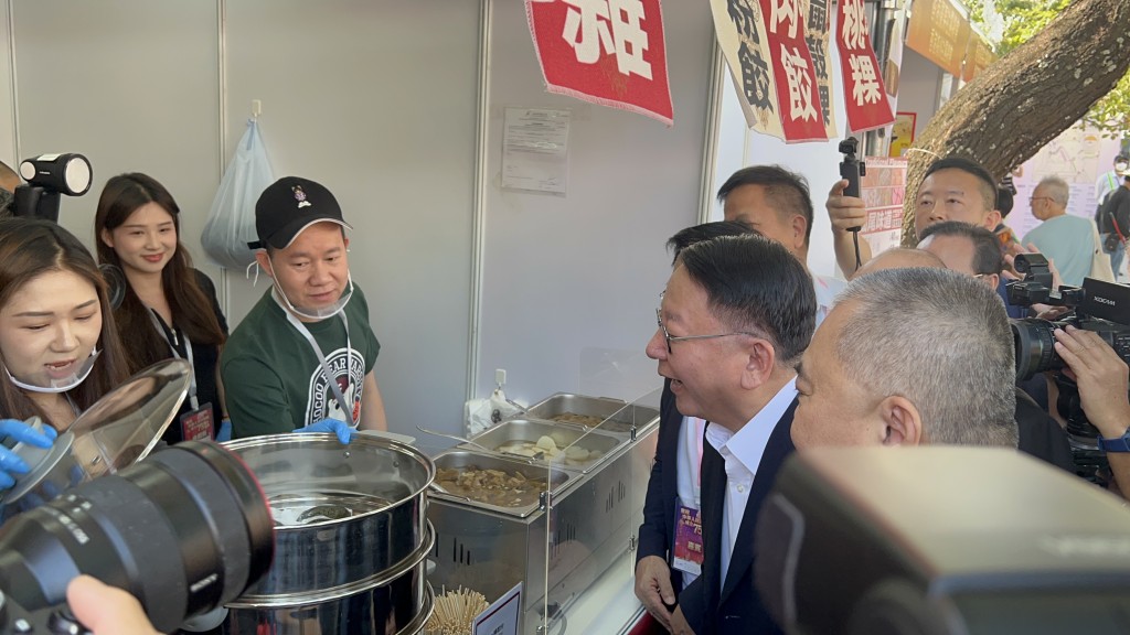 陈国基逛市集时，先试食潮汕牛肉饼，之后试饮海南咖啡。郭咏欣摄