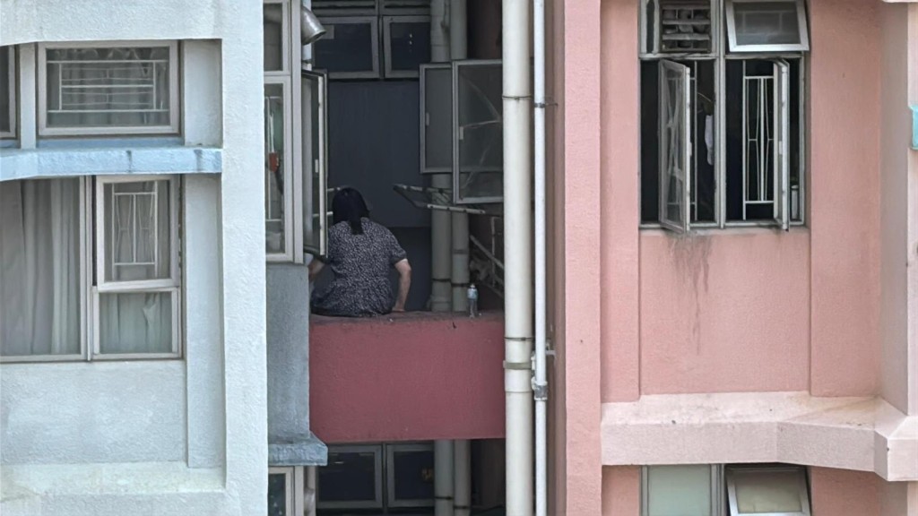 女事主危坐大廈外牆石壆。