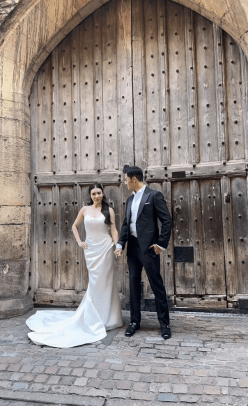 施宇琪身穿簡約純白婚紗，與未婚夫拖住手，在英國古雅的校園建築前展現幸福笑容。