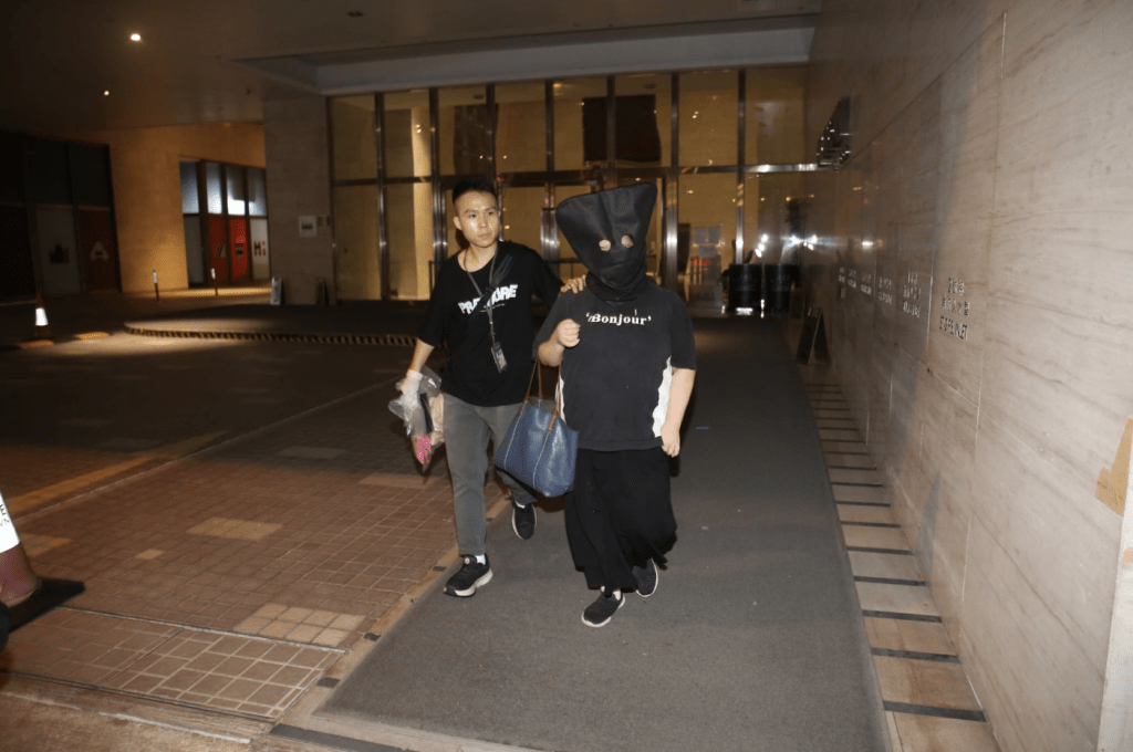 被捕女子黑布蒙頭,手挽一個大袋,被帶上警車。蔡楚輝攝 被捕女子黑布蒙頭,手挽一個大袋,被帶上警車。蔡楚輝攝