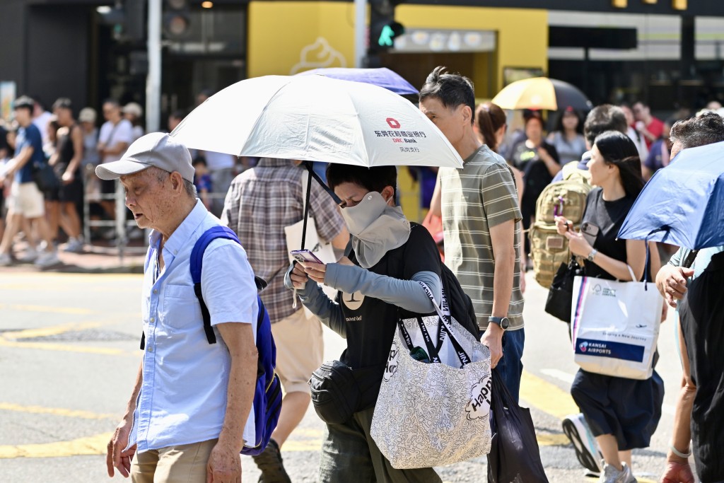 烈日當空下,市民出盡百寶防曬。劉駿軒攝 烈日當空下,市民出盡百寶防曬。劉駿軒攝