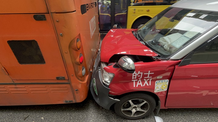 的士被夾在兩車之間。楊偉亨攝