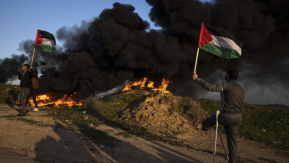巴勒斯坦人抗議以色列軍事襲擊約旦河西岸城市傑寧，在加沙城以東，焚燒輪胎並揮舞國旗。AP