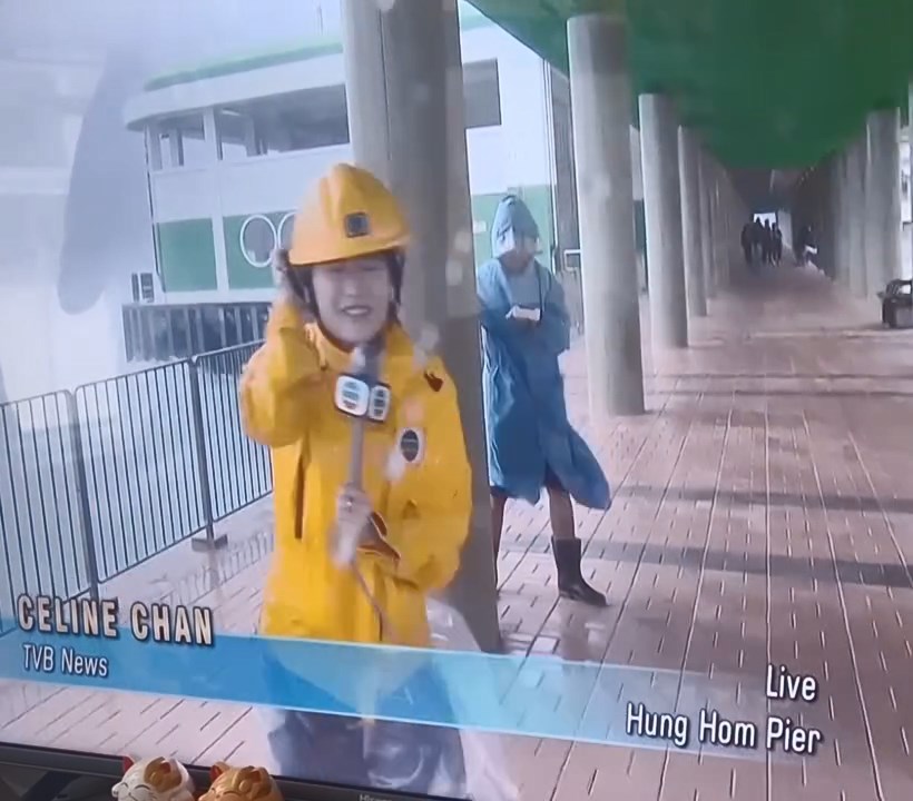 片段可見,陳尚萱穿上黃色雨衣及黃色頭盔,拿着咪高峰在紅磡碼頭海傍進行報導。 片段可見,陳尚萱穿上黃色雨衣及黃色頭盔,拿着咪高峰在紅磡碼頭海傍進行報導。