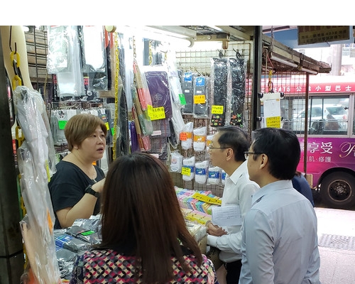 韋志成(右)上周到觀塘市中心,探訪第五發展區的搭建物用戶,了解他們的營商情況。