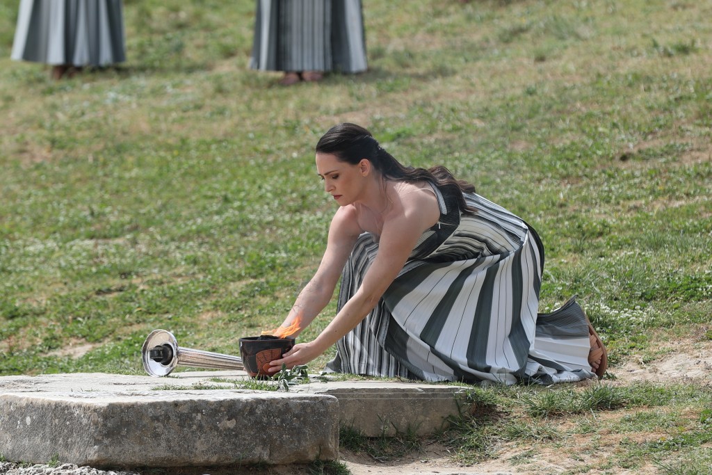 扮演最高女祭司的演员玛丽·米娜在仪式上摆放火种罐。 新华社
