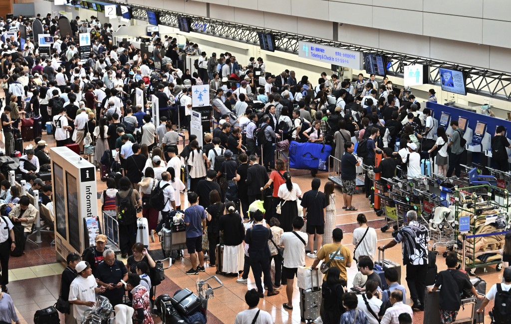 東京羽田機場一度擠滿等候辦理手續的旅客。美聯社