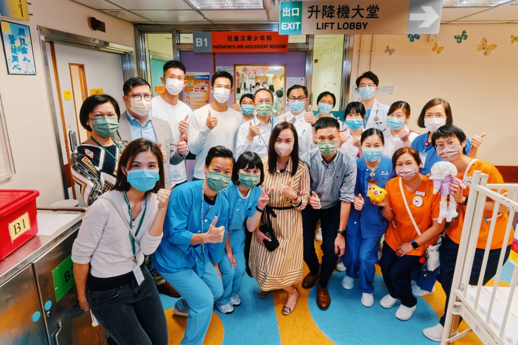 林新栋（后排左四）及王玮骏（后排左三）感谢医护人员一直紧守岗位，希望藉今次探访机会为医护人员打气。政府新闻处图片