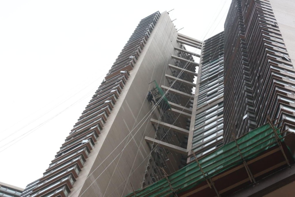 吊船在高空傾側，兩工人被困半空。