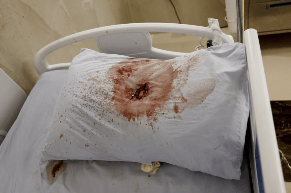 其中一张新闻报道的图片，是一名死者所用的枕头，上面有一个染了血的弹孔。路透社