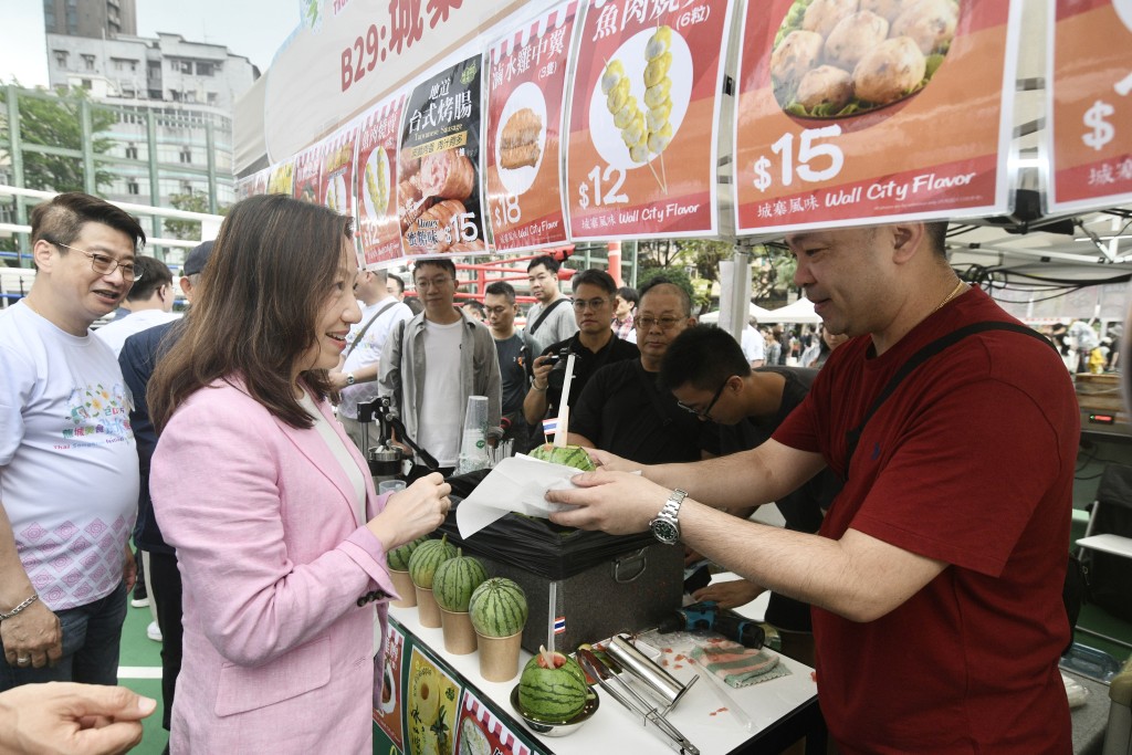 民政事务总署署长杜洁丽在市集购买了原个西瓜饮品。