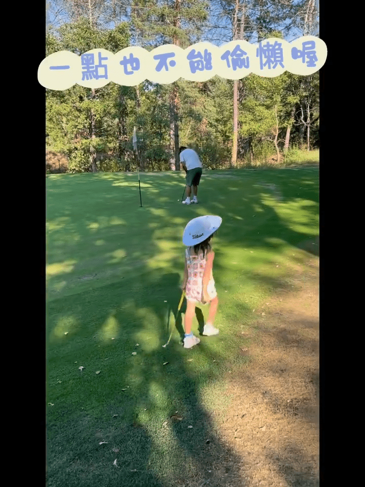 囡囡拿着兒童用的高爾夫球棍一齊打高爾夫球。