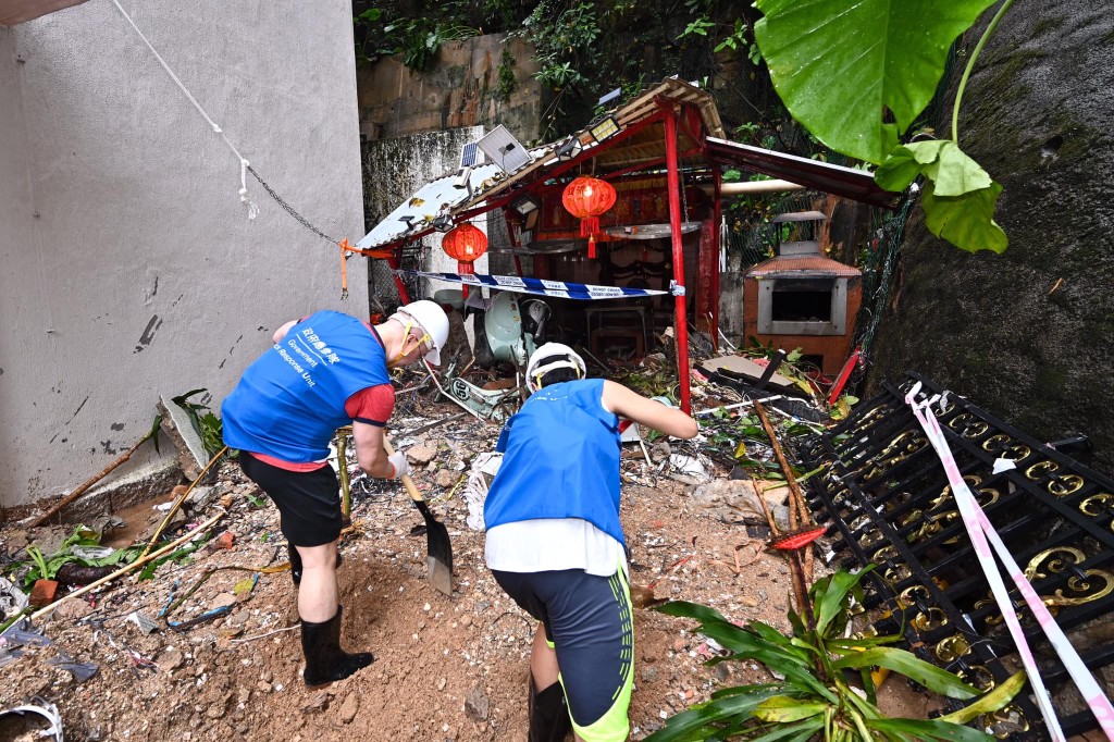应急队成员在鰂鱼涌街及筲箕湾道清理路面上的垃圾、树枝落叶，亦移走因暴雨而冲到路面的沙泥。公务员事务局fb