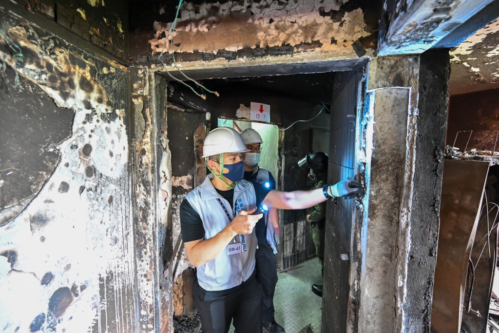 房屋局工程師於居民上樓前仔細檢查大廈走廊牆身，確保沒有尖銳物外露。