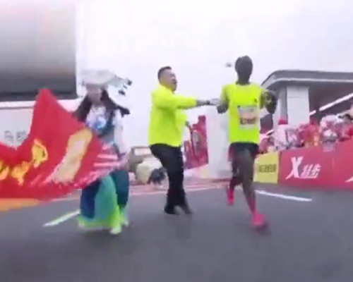 馬拉松選手衝線奪冠後被工作人員拉停。(網圖)