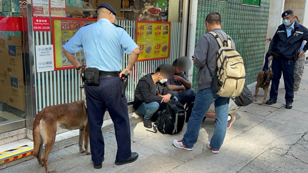 警員在寶文街1號對開截查及帶走兩名非華裔男子。楊偉亨攝