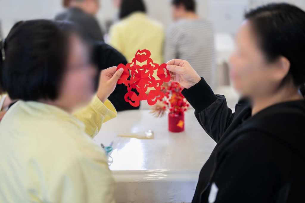 青少年在囚人士與家人一同參與中國剪紙活動，並剪出「心連心」剪紙。