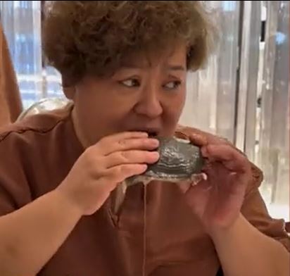 中年妇吃得津津有味。(互联网)