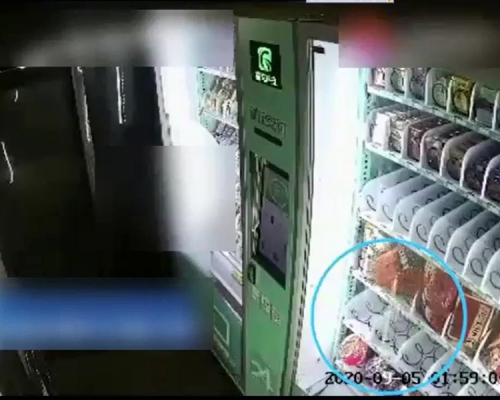 男子用木棍弄掉食品。閉路電視截圖