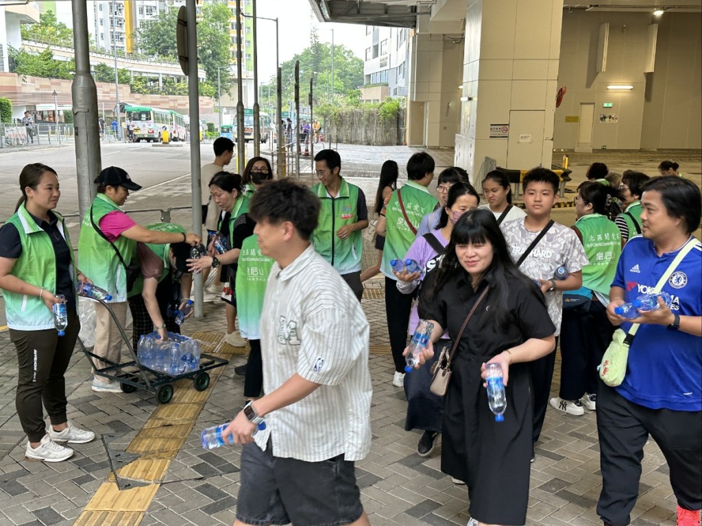 關愛隊在邨內主要通道派水供居民應急。 關愛隊在邨內主要通道派水供居民應急。