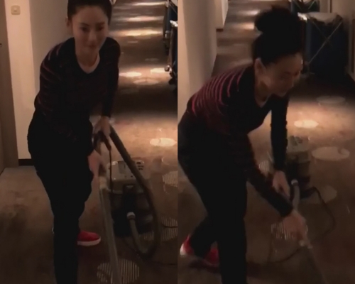 栢芝扮清洁工人吸尘。