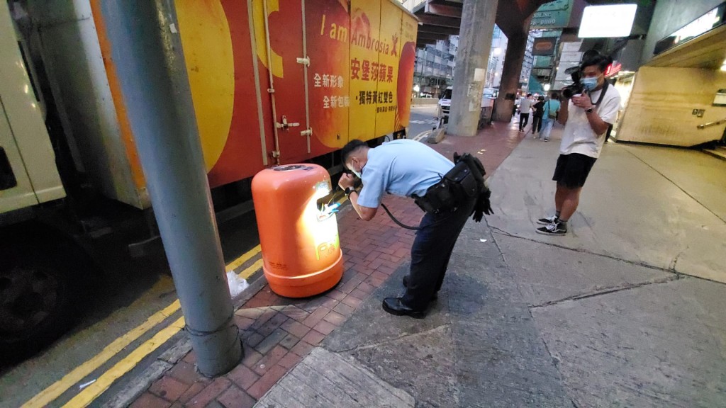 警员搜索附近垃圾桶是否有留下凶器。
