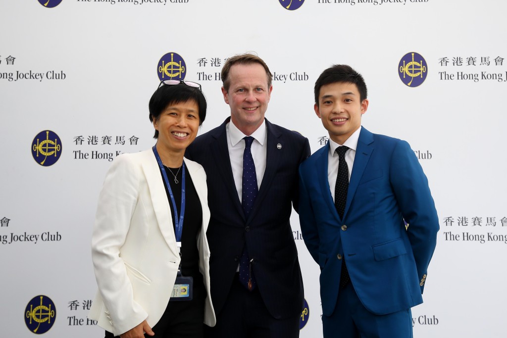 香港赛马会赛马事务执行总监夏定安（中）、赛马人才培训中心高级经理暨见习骑师学校校长陈念慈（左）祝贺黄皓楠未来前程似锦。