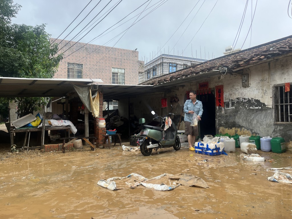 白沙鎮受災區洪水漸退民眾在清理屋院。中新社