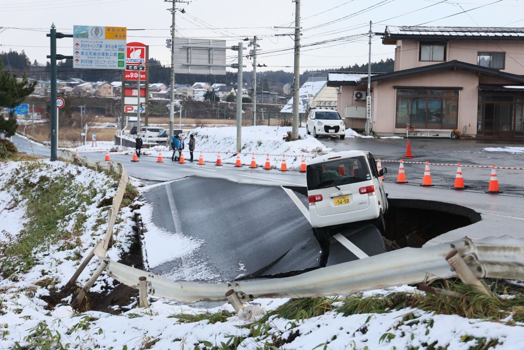 早前地震造成道路塌陷，汽车受困。法新社