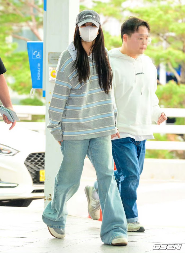 Jisoo在工作人員陪同下現身機場。