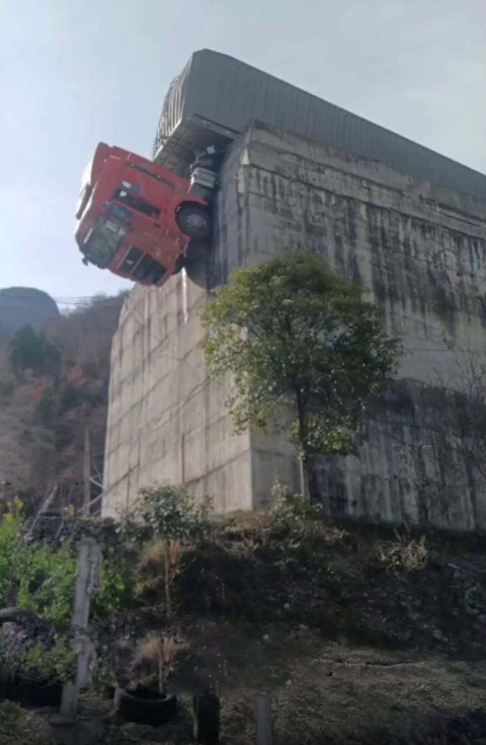 剎車失靈貨櫃車衝出公路，拖頭90°懸掛半空。陝西消防