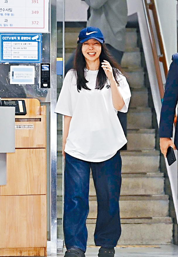 閔熙珍在受查8小時後，笑容滿面見傳媒。
