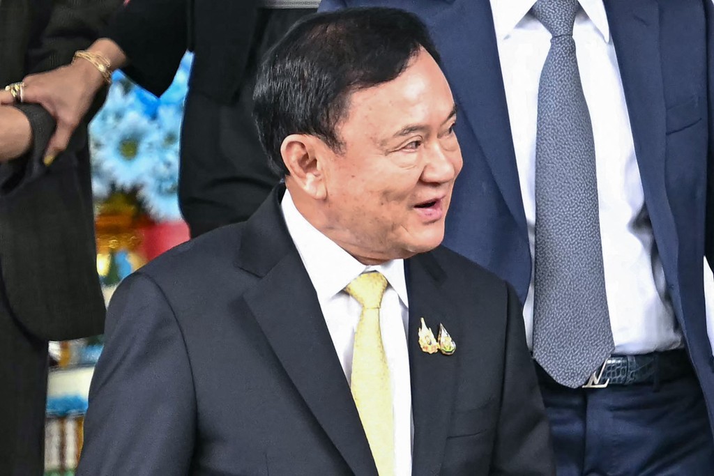 他信離開法院時面露笑容。法新社 他信離開法院時面露笑容。法新社