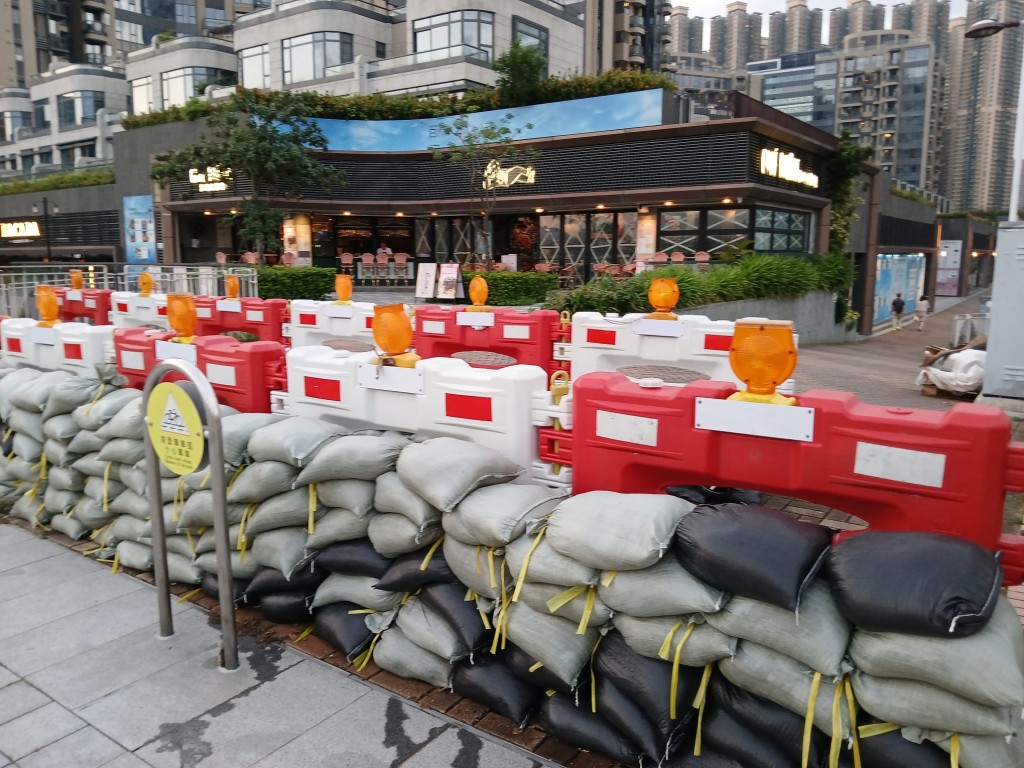 超強颱風「山竹」2018年襲港時重創將軍澳 海濱長廊，如今再面對另一股超強颱風「樺 加沙」，政府與居民都嚴陣以待。  附著水馬的雙重沙包陣，已妥妥的放在兩邊 大路出入口。沙包靜觀昨日暴風雨前夕的落 霞，大有笑看風雲的氣慨。