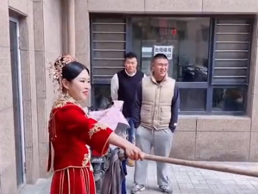 新娘拿起地拖,豪邁氣勢震懾擬婚鬧的朋友。
