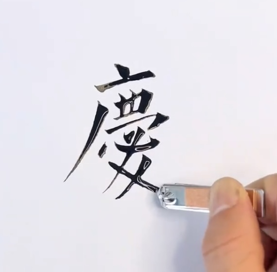 男子挑戰用「奇葩工具」寫書法。新京報 男子挑戰用「奇葩工具」寫書法。新京報