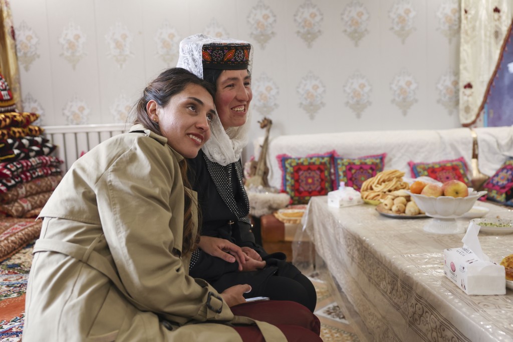 在位于新疆塔什库尔干塔吉克斯坦自治县瓦恰乡夏布孜喀拉村的家中，艾尔开牙·多力开（左）依偎著前来参加大家庭聚会的堂姐。 新华社
