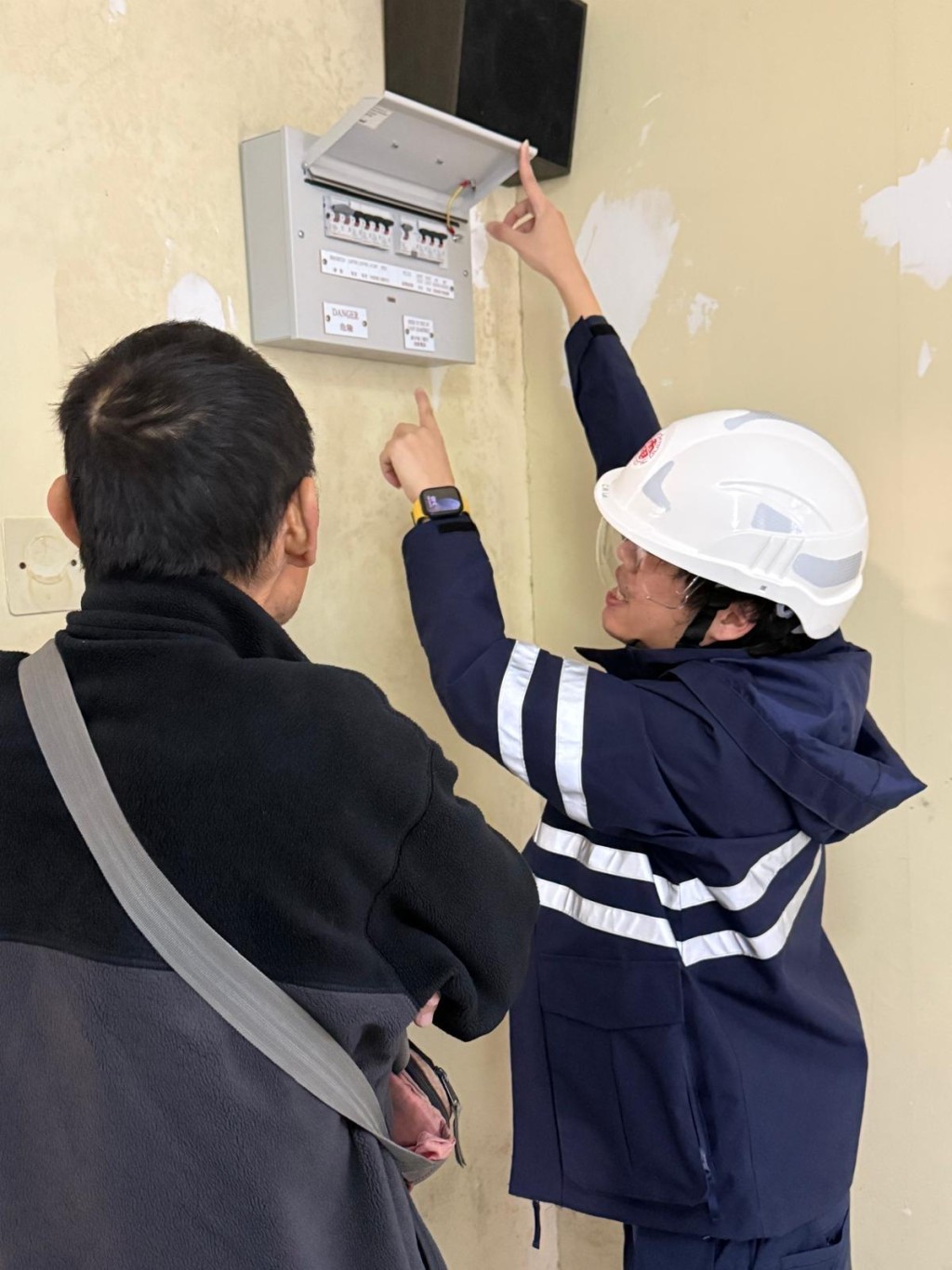 Jimmy(右)習慣在完成工作後,「多走一步」向客戶提供電力安全資訊,例如提醒 客戶應定期檢查配電箱內的漏電斷路器。 Jimmy(右)習慣在完成工作後,「多走一步」向客戶提供電力安全資訊,例如提醒 客戶應定期檢查配電箱內的漏電斷路器。