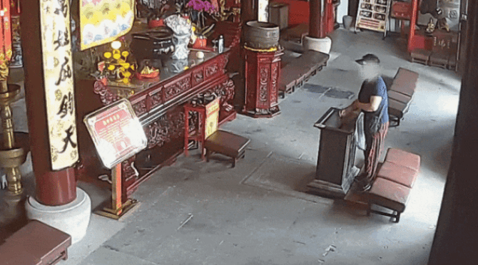 上海女子從寺廟功德箱裏偷走香油錢。上海警方 上海女子從寺廟功德箱裏偷走香油錢。上海警方