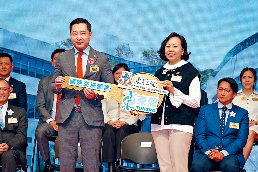麦美娟局长（右）将「锁匙」交予韦浩文（左）主席，象徵「东蒲」内的国际交流营舍投入运作。
