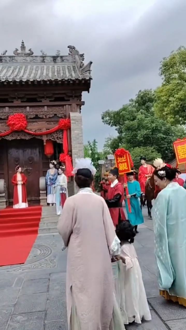 中式仿古婚禮微電影興起，催生許多臨演工作機會。抖音＠B    大金店飛龍舞獅花轎儀仗隊
