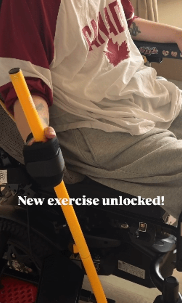 阿Mo透過握住一根固定在地面的棍子，控制其直立移動，有助訓練駕駛電動輪椅所需的部分肌肉力量。