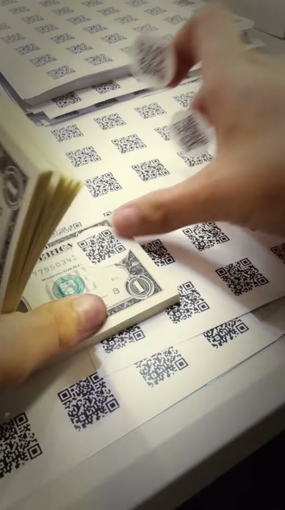 工作人員在每一張1美元紙鈔都貼上QR code 。Youtube