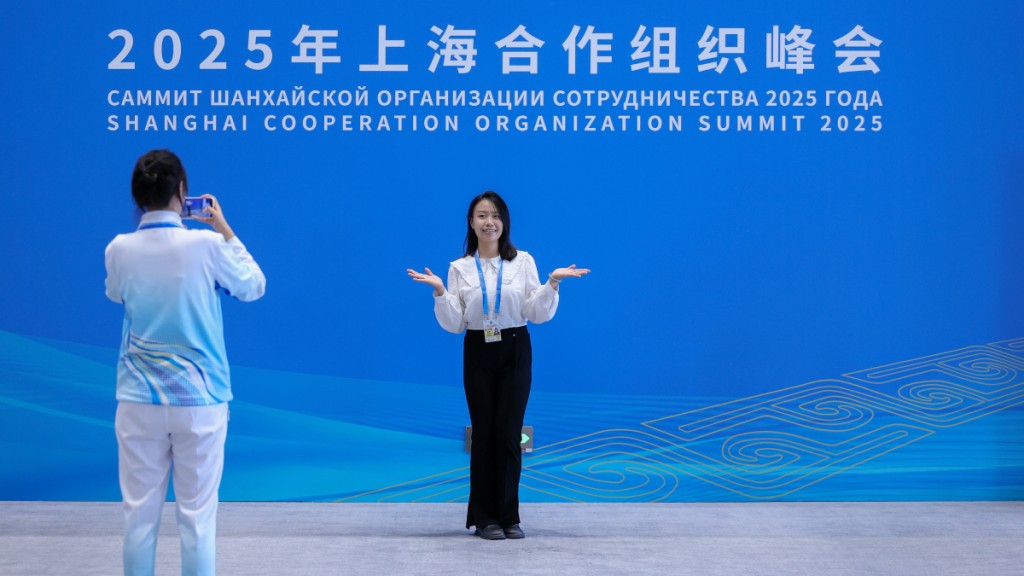 上海合作組織峰會明日在天津揭幕,工作人員在標識留影。中新社