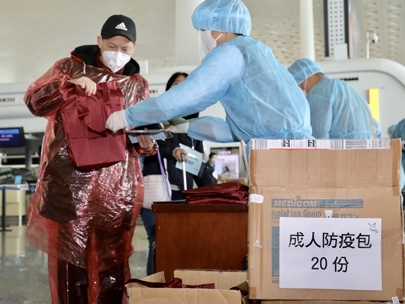負責登記和處理防疫包的人員與昨日一樣,穿上藍色保護服裝和頭套,並佩戴口罩及防疫膠片。