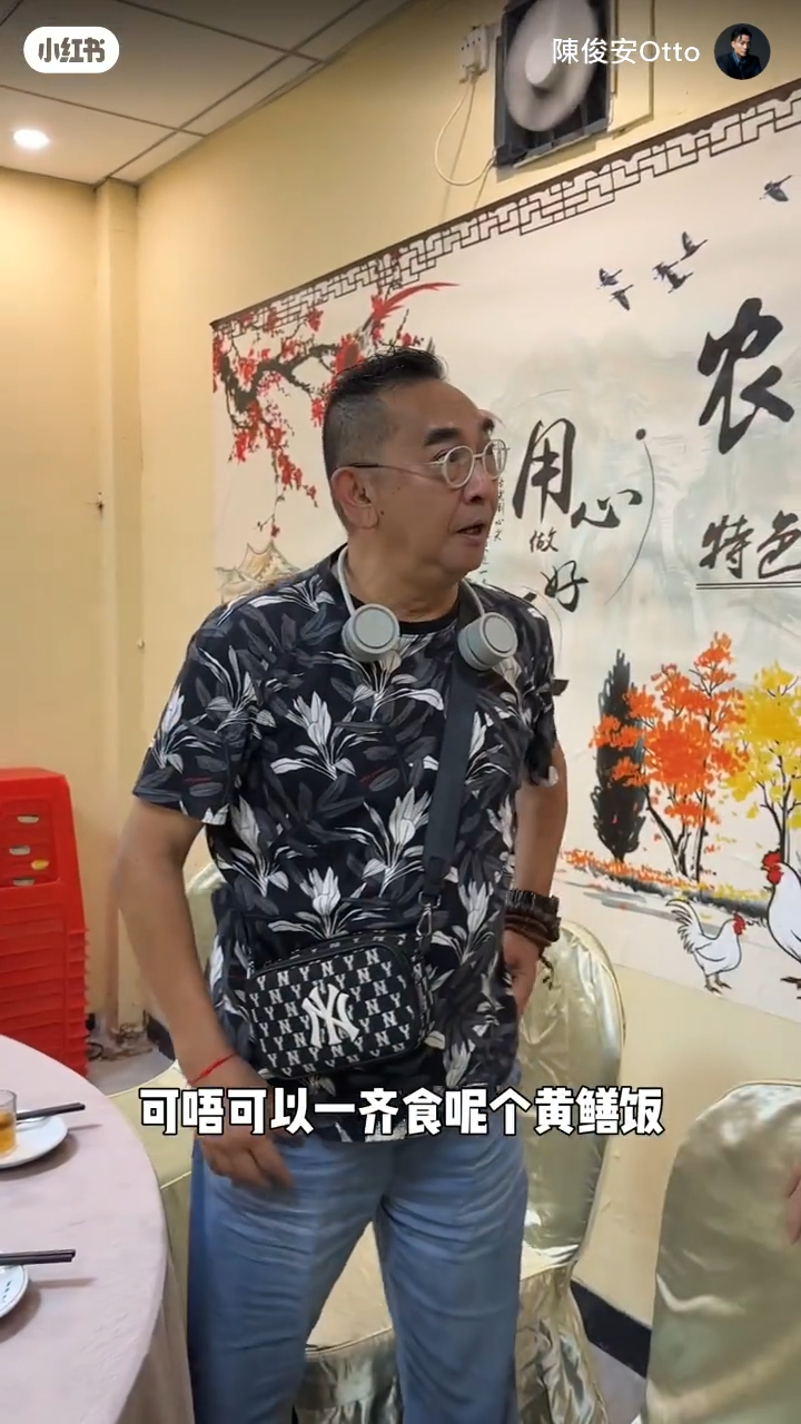 李鸿杰身穿黑白色花花T恤配蓝色牛仔裤，手上戴上多串佛珠链，打扮年青。