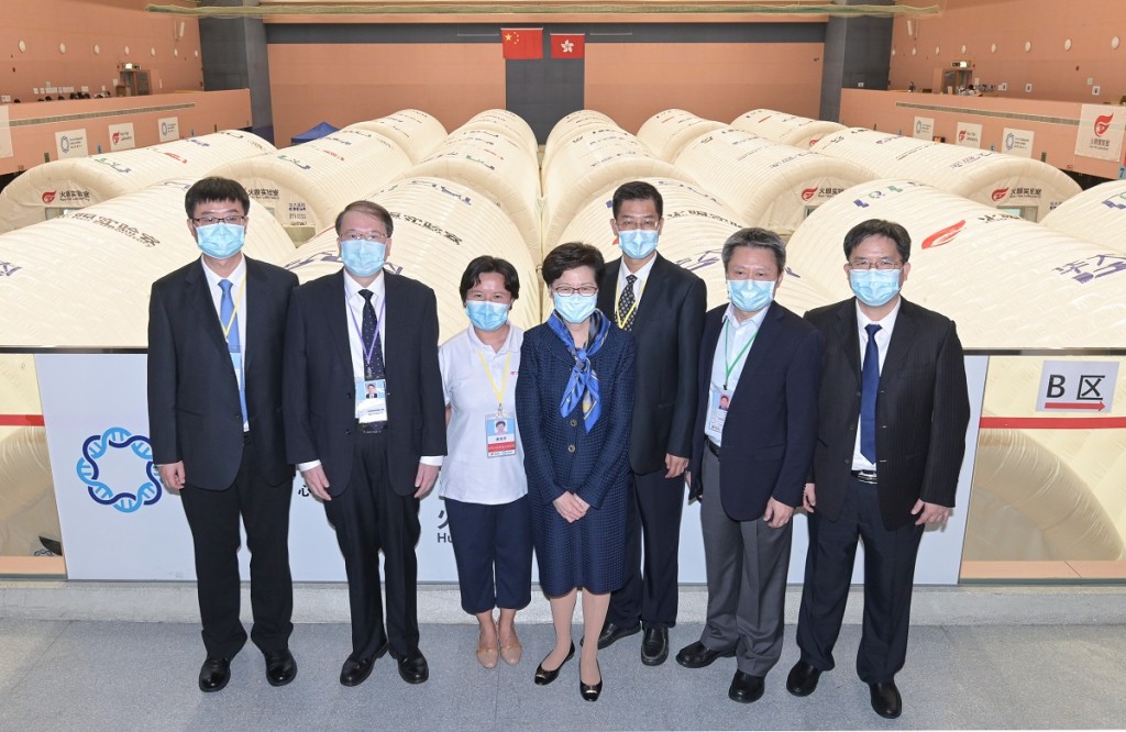 圖示林鄭月娥與支援隊總領隊李大川(右三)、實驗室總指揮唐美芳(左三)、支援隊(廣東組)隊長余德文(右二)、支援隊(福建組)隊長張永裕(左二)、支援隊(廣西組)隊長龐軍(右一)和衞健委醫療管理服務指導中心處長趙靖合照。政府新聞處圖片