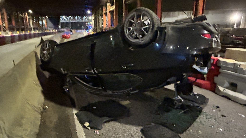 私家車失控撞水馬，四輪朝天橫亙路中。蔡楚輝攝