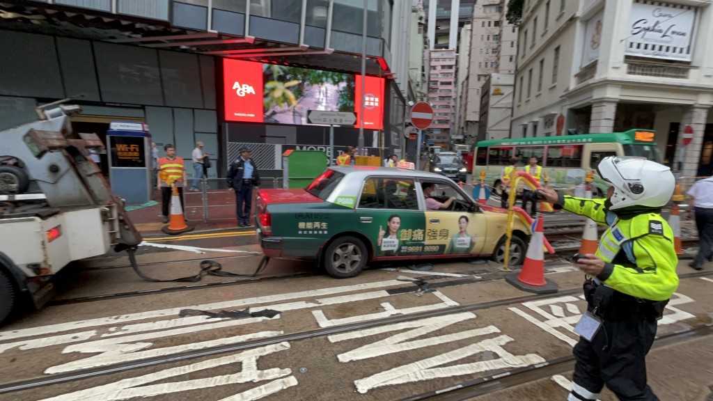 拖車奉召到場將的士拖離電車路軌。