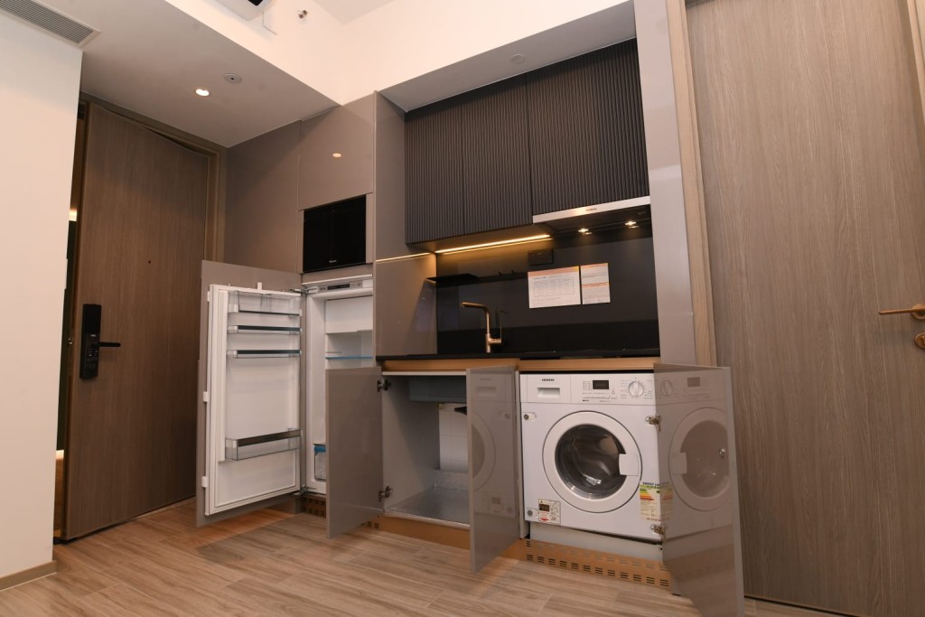 開放式廚房配以灰色儲物櫃拼砌黑色直紋廚櫃及黑色台面。